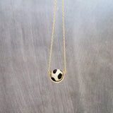 Eclipse Necklace - black white spotted round stone in semicircle pendant, Tibetan Dzi agate bead ball, giraffe print in gold half circle - Constant Baubling