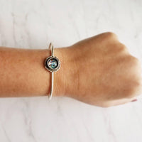 Silver Cuff Bracelet - oval open bangle w/ antiqued oxidized finish - thick simple wire w/ glass swirl ocean waves art in round deep bezel - Constant Baubling