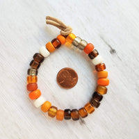 Autumn Bracelet - orange, tan, brown glass big bead tie on faux suede cord, chunky glass pony roller beads, VSCO girl, fall color jewelry - Constant Baubling