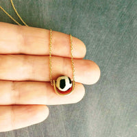 Eclipse Necklace - black white spotted round stone in semicircle pendant, Tibetan Dzi agate bead ball, giraffe print in gold half circle - Constant Baubling