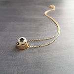 Eclipse Necklace - black white spotted round stone in semicircle pendant, Tibetan Dzi agate bead ball, giraffe print in gold half circle - Constant Baubling