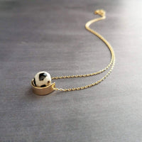 Eclipse Necklace - black white spotted round stone in semicircle pendant, Tibetan Dzi agate bead ball, giraffe print in gold half circle - Constant Baubling