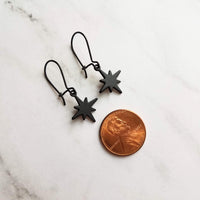 Black Star Earrings, small matte black sunburst charm, latching kidney hooks, night earrings, celestial earring starburst earring north star - Constant Baubling